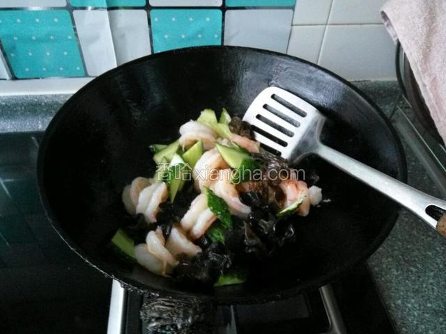 在下入木耳和黄瓜片，加入少许盐和鸡汁快速炒匀即可出锅了