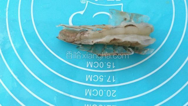 开始整理大虾，用剪刀剪去虾头和虾尾，剪去虾须。然后用剪刀从中间沿虾的脊背剪开，剥离虾壳，挑出虾腺！