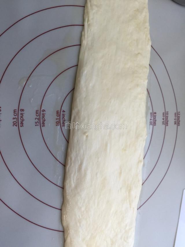 将醒发好的面团按扁成长条形如图。