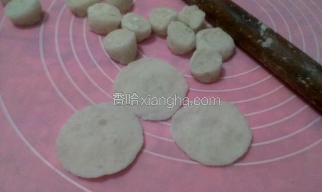 把
粉团搓成条，切成8克左右的剂子，像擀饺子皮一样擀开