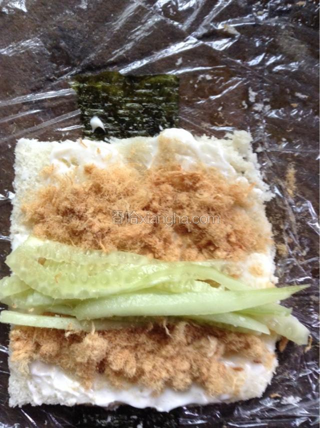 翻过来，海苔在下面包片在上，涂上沙拉酱，再放上肉松，再放点青瓜，顺势卷起来。