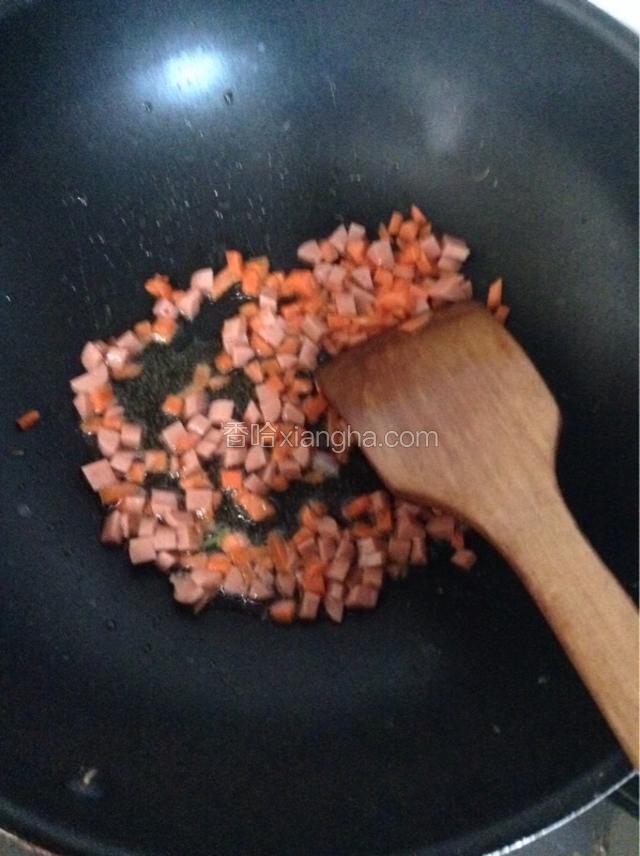 锅中放少许油，下胡萝卜和火腿丁煸炒。