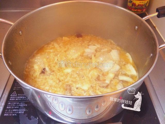 然后把酸菜等食材换到煮锅里面，加入两碗左右的开水（淹过食材一点），盖上锅盖小火慢煮开锅