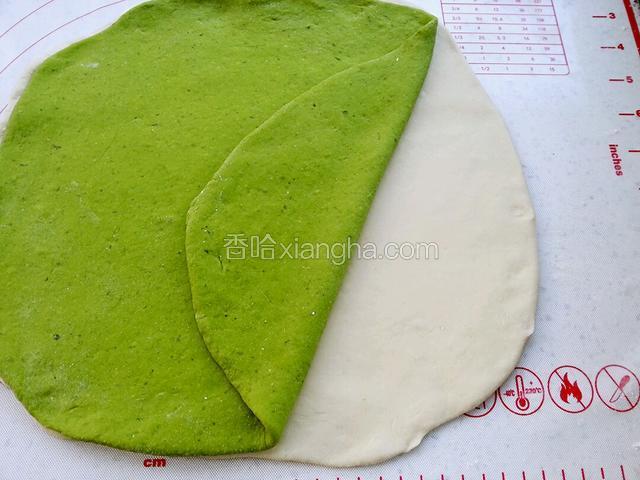 两色面都擀成相同大小的面片，白色的在下面