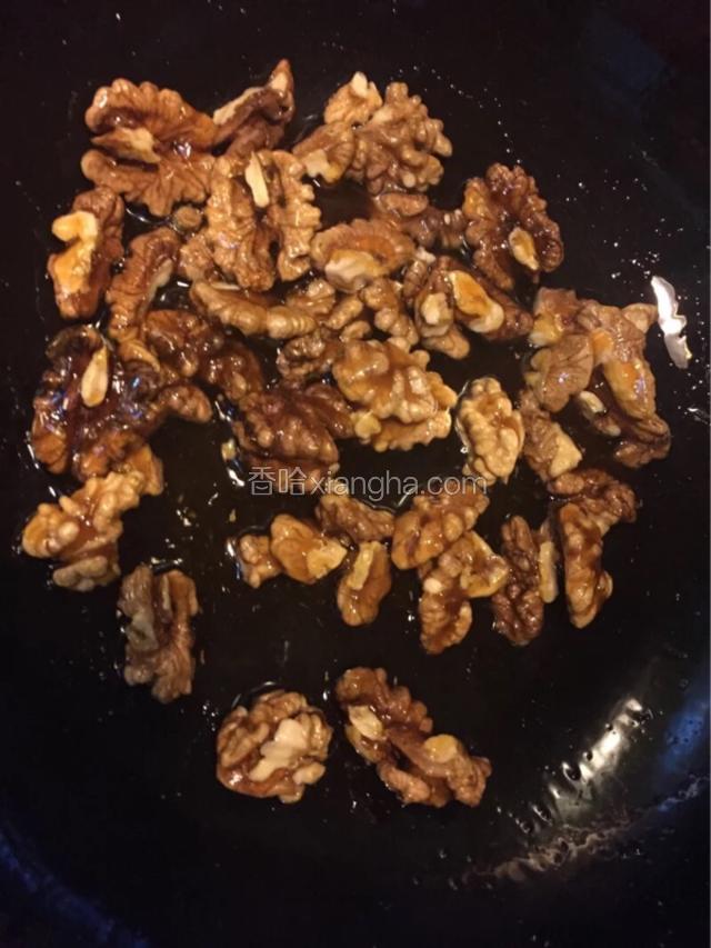 冰糖融化，变成深褐色，不断的冒细密的气泡，并开始粘稠，下入核桃仁快速的使糖浆附着在核桃仁上
