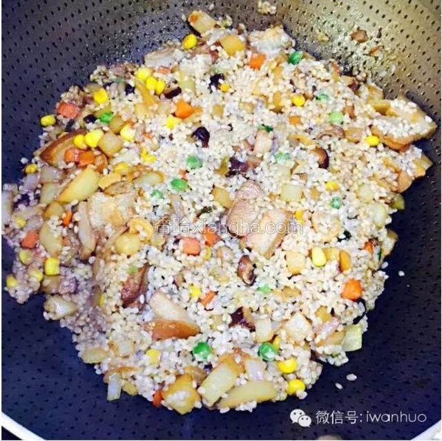泡好的米滤水后一起放入炒锅翻炒。