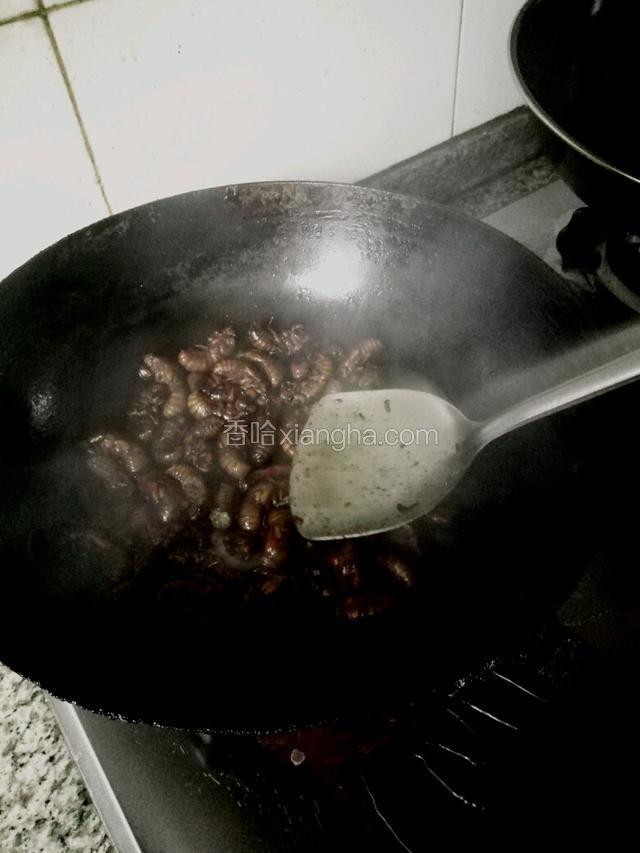 用铲子按压金蝉把水分炒出来，让盐入味