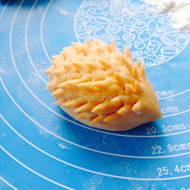 用剪刀在面团的背部均匀的剪出小刺