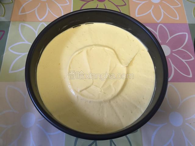 开始制作慕斯蛋糕，蛋糕片放入模子底部，然后倒入芒果慕斯酱，表面抹平。