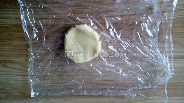 冷藏后拿出白色的面团，用保鲜膜包住面团来擀薄饼，这样会比较好饼干皮的薄饼，成型后比较好取下来。