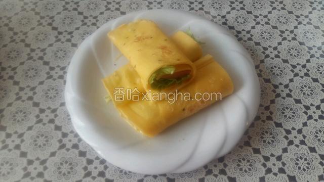 铺好饼，放入生菜和两片火腿，卷好，中间切断摆盘