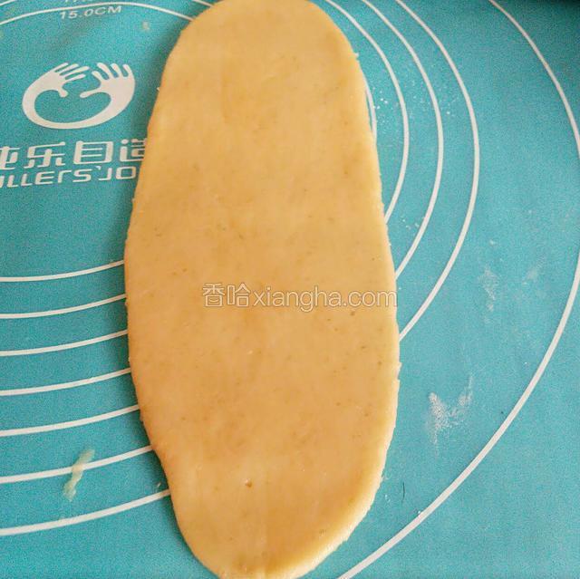 取一块面团轻轻压扁，用擀面杖擀成舌状