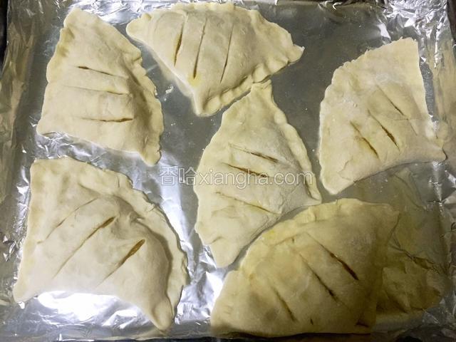 饼捏好后放入铺好锡纸的烤盘上，用刀在饼上均匀切几道口子。