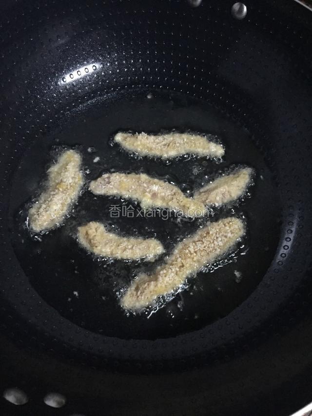 锅中倒入适量的油，烧到六七成热时关小火，把鸡柳放进去炸