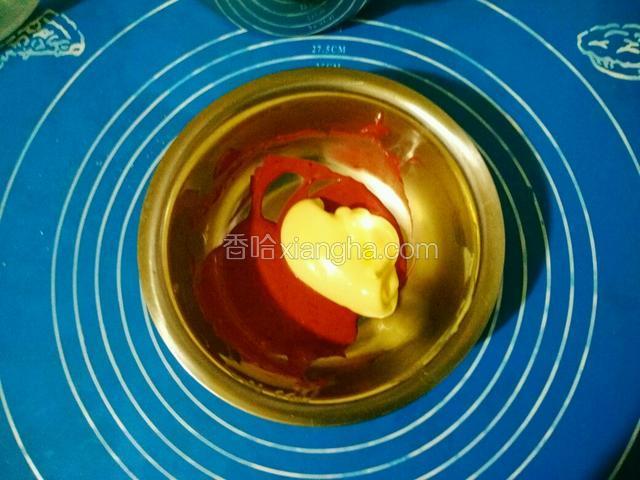 用刮刀挖出一勺蛋糕糊放在刚才拌好红曲粉的蛋黄糊中。