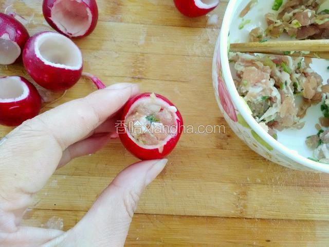 取一个小萝卜，用筷子把肉馅放进小萝卜里