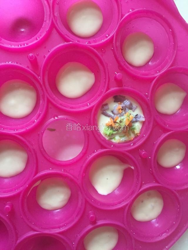 一小时后将面糊倒入乐葵棒棒糖蛋糕模具的1/3中，放入章鱼丁，胡萝卜，甘蓝丁。
