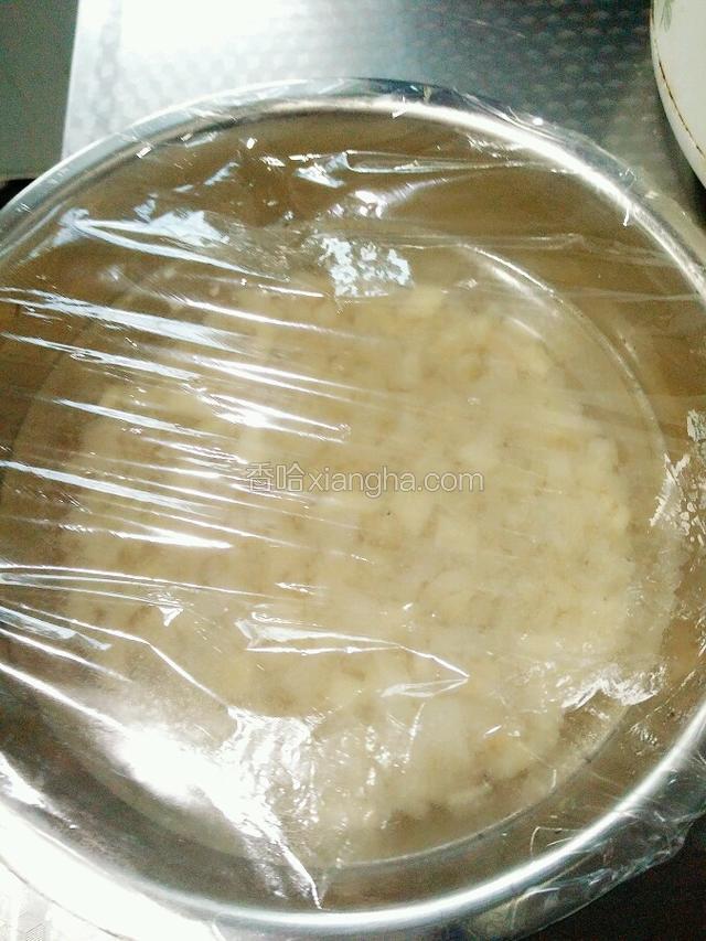 把装入猪皮丁的小盆用保鲜膜盖好，保鲜膜上面扎几个小眼。
