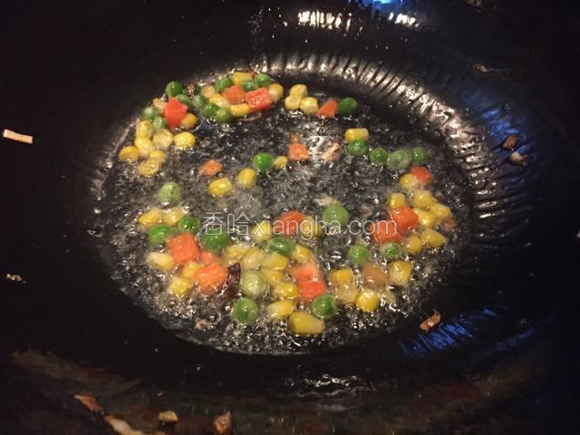 锅中留油，油热加入什锦蔬菜丁
