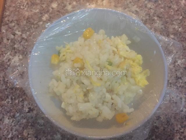 保鲜膜盖在碗上面，放入炒好的饭
