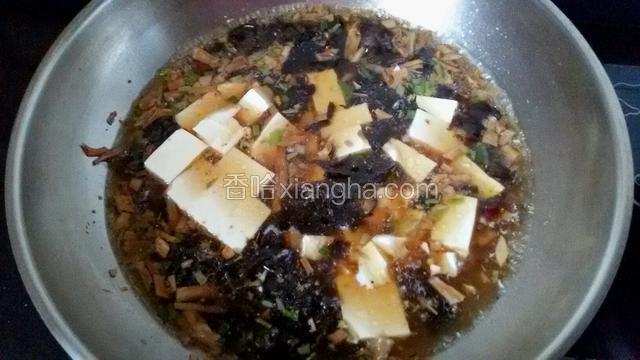 把内脂豆腐切成方块放入汤中。