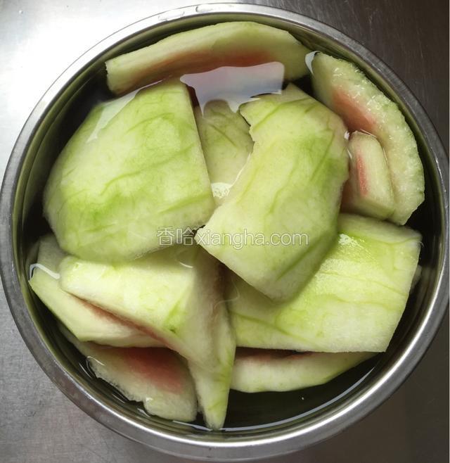 西瓜皮去绿皮去红瓤，用加盐的清水泡二十分钟；