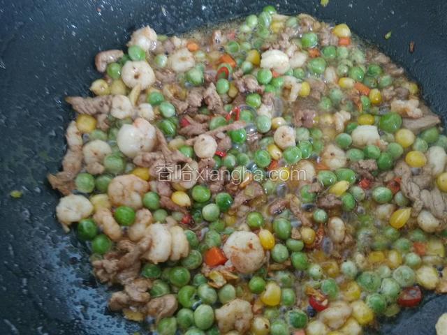 将玉米粒，豌豆粒，虾仁倒进锅里翻炒均匀，盛盘备用。