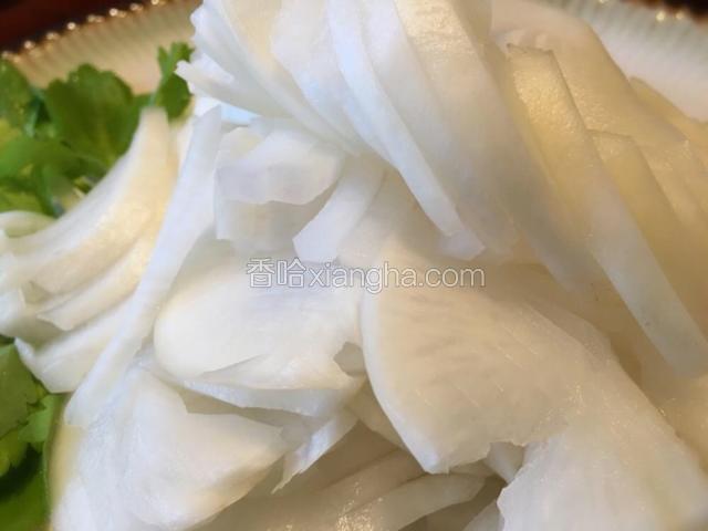 取出萝卜挤一下水分撕成片摆盘，芹菜叶点缀即可。