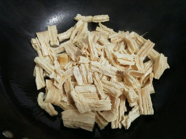 在锅中倒入少许油，放入腐竹