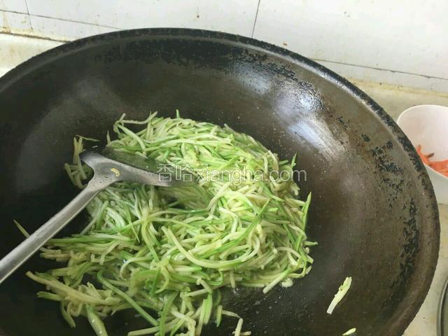 待到油开了，将盘子中的，西胡丝，放入锅中爆炒。