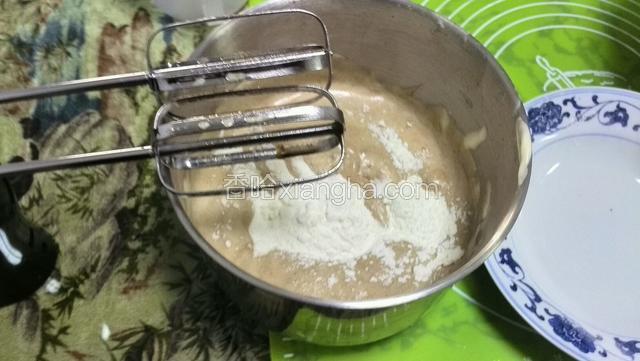 取三分之一蛋糊倒入混合液中搅拌均匀，加入过撒的面粉用打蛋器低速打8秒