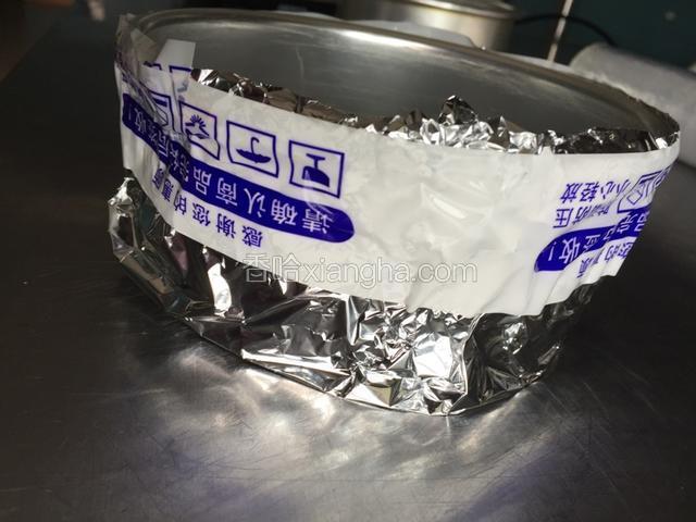 用不活动的模具就不用这么麻烦了、我用的是活动膜、要包好不露水、先包一层保鲜膜注意不要弄烂、用胶带缠住！再包一层锡纸！同样用锡纸包住、包到顶部、因为水要过半