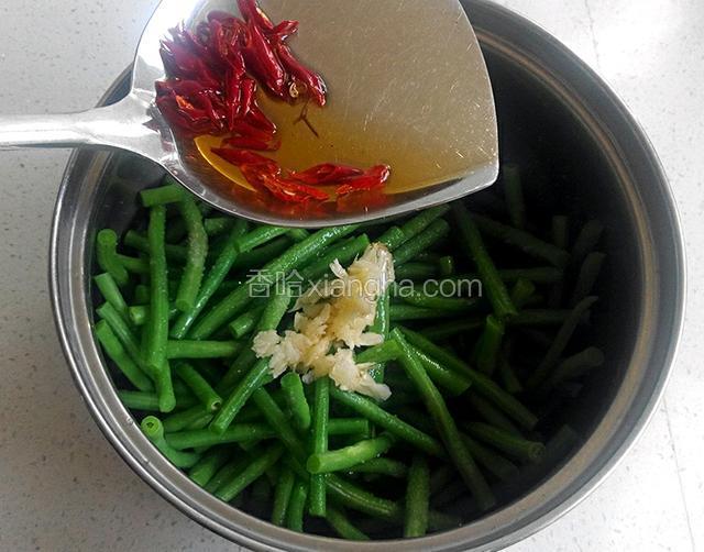 将热油和干辣椒倒在大蒜上面，拌匀即可