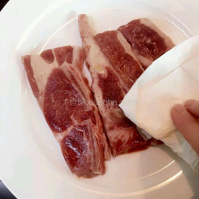 用厨房纸巾吸干牛仔骨表面水份
