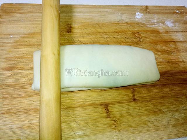 折好的面片，再次用擀面杖顺着长度擀下去。
