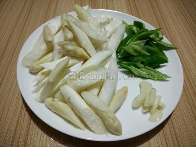 芦笋削去根部老皮斜切段，青椒去籽斜刀切，蒜切片