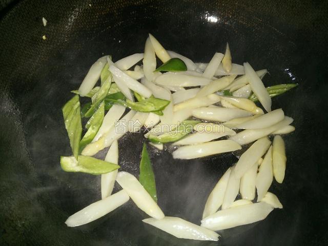 重新热锅，下少许花生油煸香蒜片后，下入青椒和白芦笋一起急火快炒片刻，加少许盐翻炒均匀