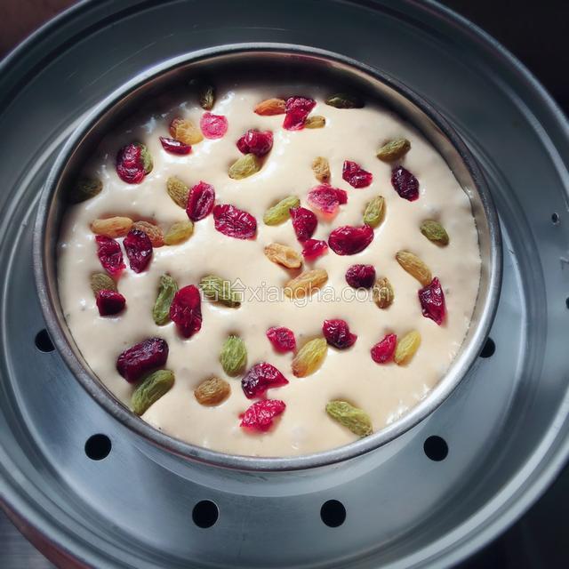 面糊发酵至两倍大的时候，一边撒上葡萄干，蔓越莓干。