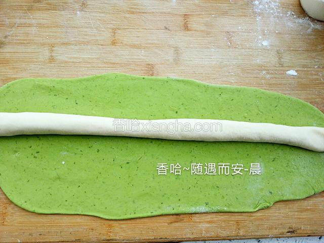 取白面和绿色面，绿色面擀成片状，白面揉成条状，放在绿色面上