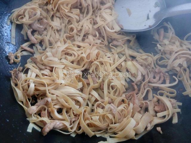 加入少许清水，倒入豆腐皮丝，继续翻炒