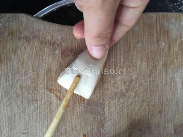 左手食指和拇指提起尖的一头，右手拿筷子按住底部