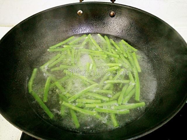 锅里水烧开后，放少许盐、几滴油，倒入长豆角焯水3分钟。