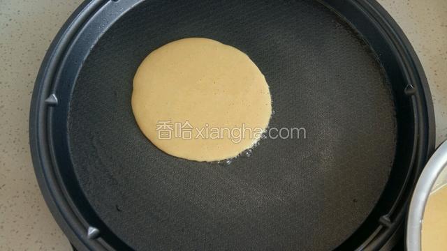 用勺子舀一勺玉米糊垂直倒入电饼档