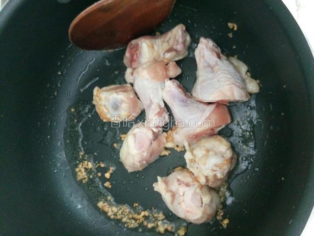 炒锅下油加热，加入蒜蓉炒一下，加入鸡腿