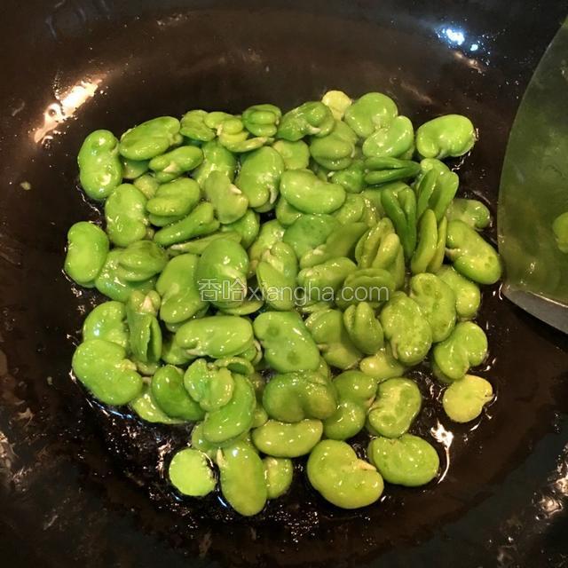 净锅放入适量的油，大火烧至九成热，下入蚕豆翻炒。