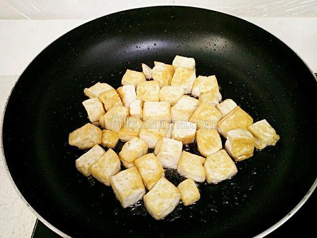 锅里放适量油，倒入豆腐煎至两面金黄。