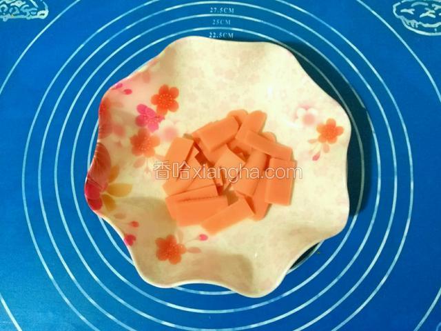在发酵的过程中准备火腿肠，将火腿肠切成片。