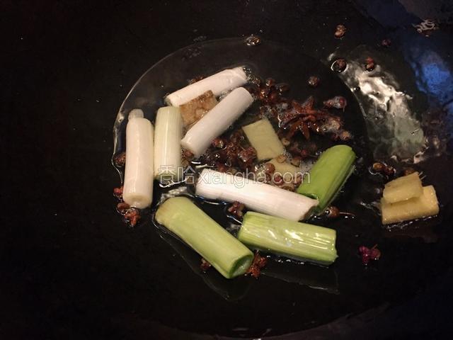 热锅冷油，油热加入花椒，八角，葱段，姜片炒香
