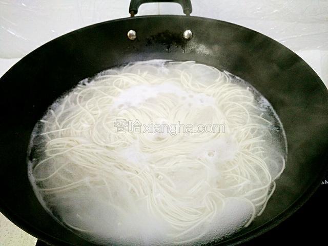 锅里水烧开，加少许盐、几滴油，放入面条煮熟。