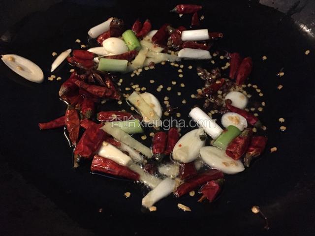 锅中留油，油热加入葱段，姜丝，八角，花椒，干辣椒炒出香味
